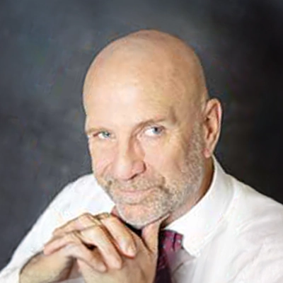 Chiropractor K.J. Shannan With Chin Resting On Hands