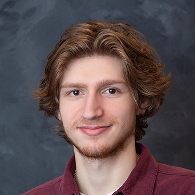 Massage Therapist Jacob Williams Smiling On Blue Background